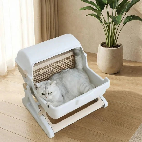Chat couché dans sa litière automatique pour chat
