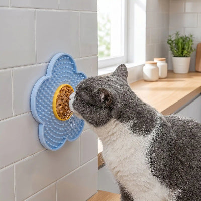 Chat qui lèche son tapis de léchage chat bleu en vertical sur carrelage