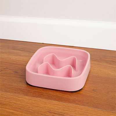 Gamelle anti glouton chat FeliFit carré rose posée sur sol en parquet