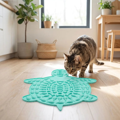 chat qui vient renifler son tapis de léchage pour chat bleu